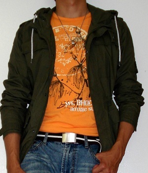 A Light Orange T Shirt Underneath A Dark Green Jacket