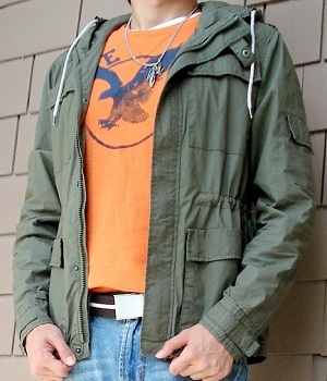 Wearing a dark green jacket and an orange graphic tee