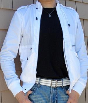 White perforated jacket with a black t-shirt inside and a pair of light blue jeans